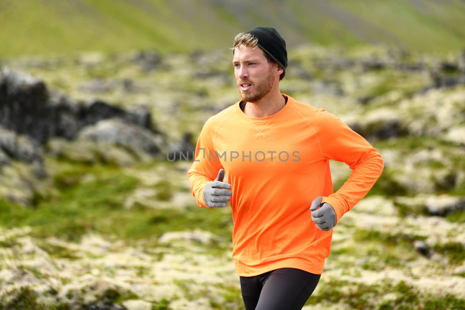 Runner. Sport running man in cross country trail run. Male athlete exercising and training outdoors in beautiful mountain nature landscape.