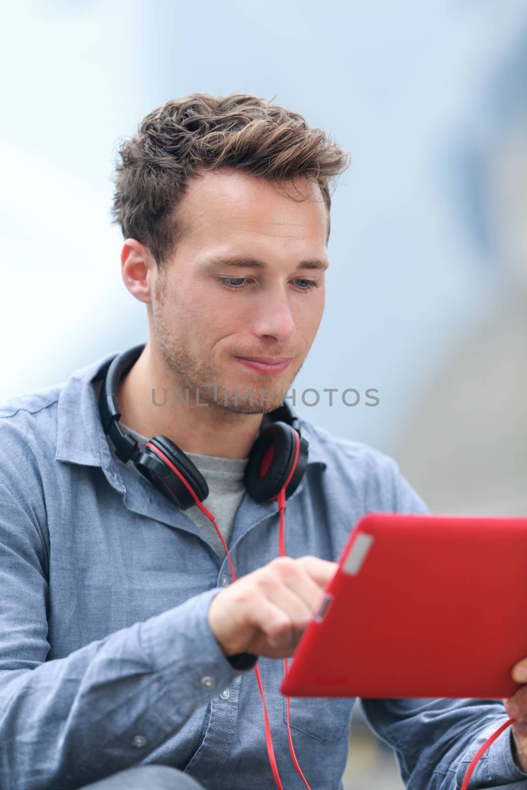 Urban young professional man on tablet by Maridav