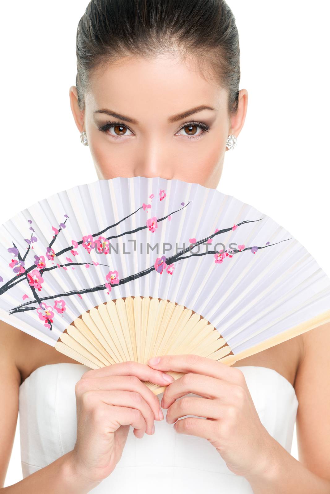 Asian chinese woman looking seductive with paper fan. Beauty portrait of female model face with closeup on eyes.