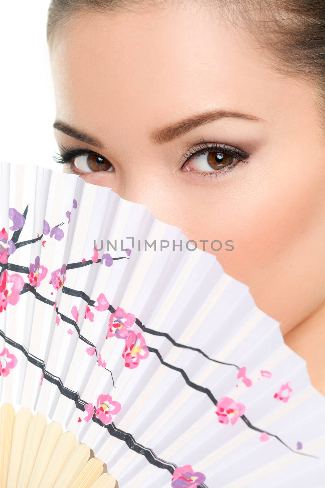 Asian beauty - seductive eyes woman chinese or japanese. Eye makeup Asian look with paper fan. Beauty portrait of mixed race Asian / Caucasian female model on white background. Close up on eyes.