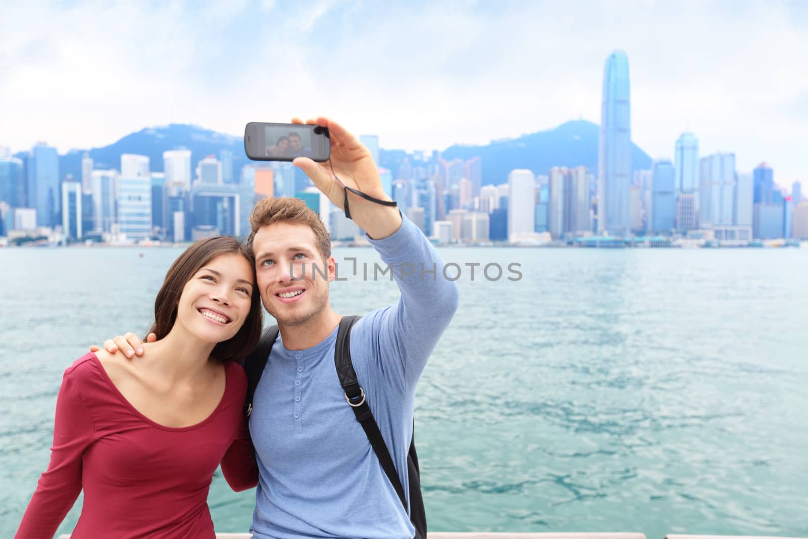 Selfie tourist couple taking picture in Hong Kong by Maridav