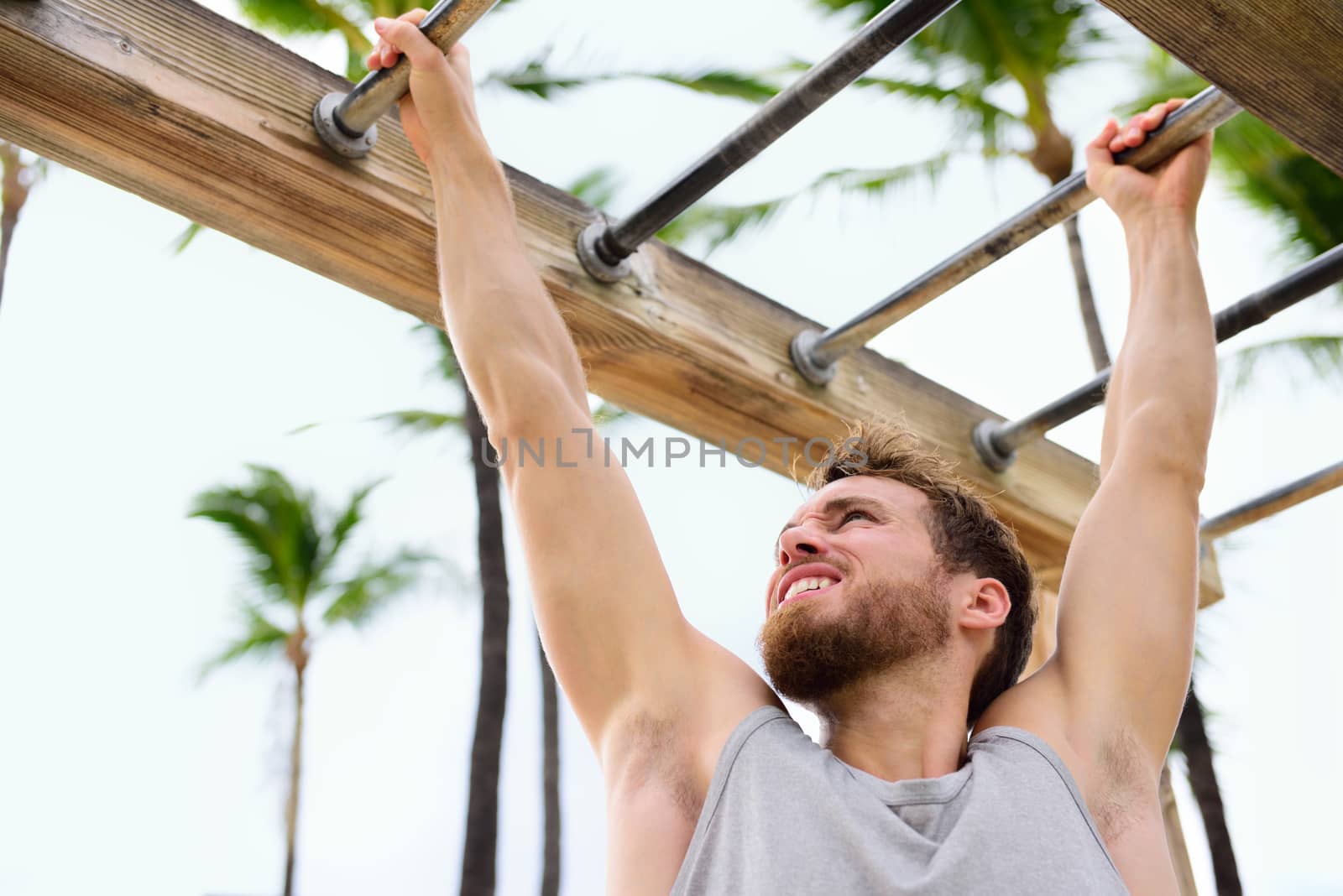 Exercise fitness athlete exercising on monkey bars by Maridav