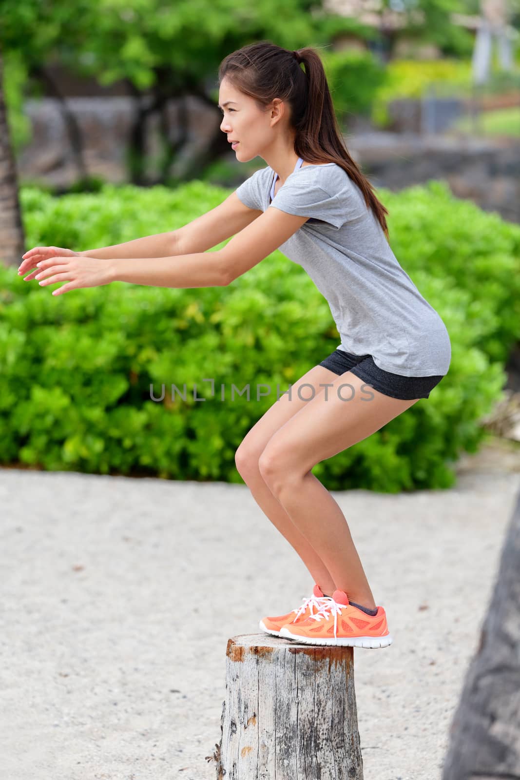 Fitness woman bench jump squat jumping on beach by Maridav