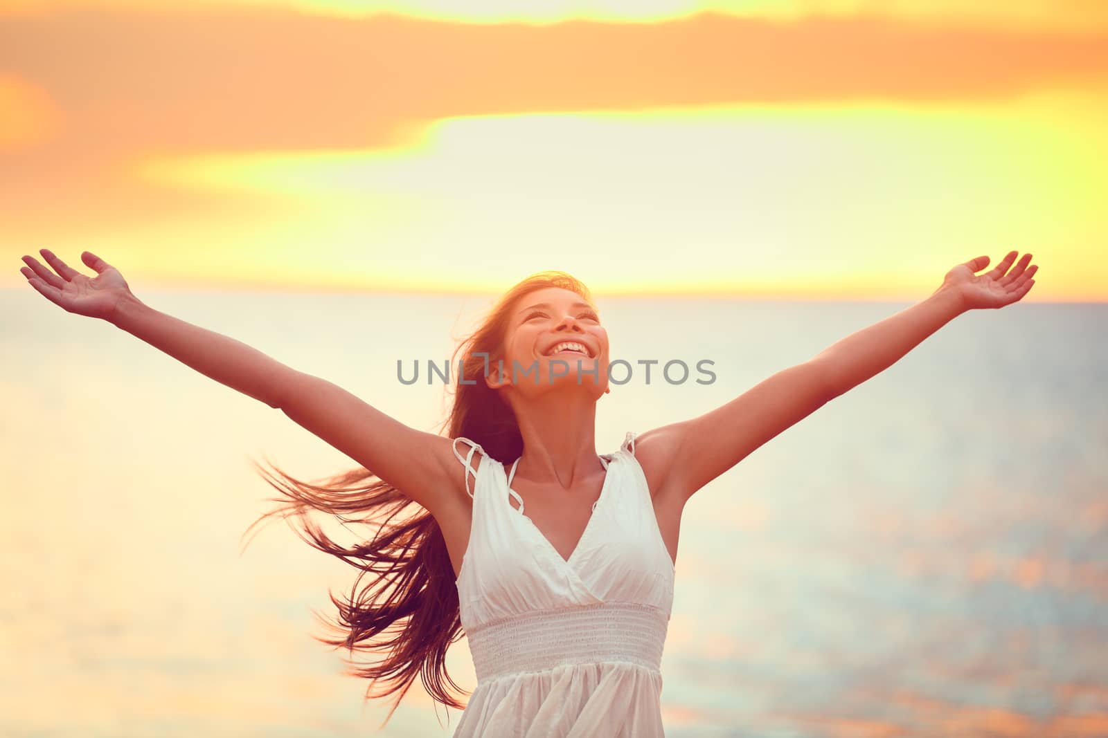 Free happy woman praising freedom at beach sunset by Maridav