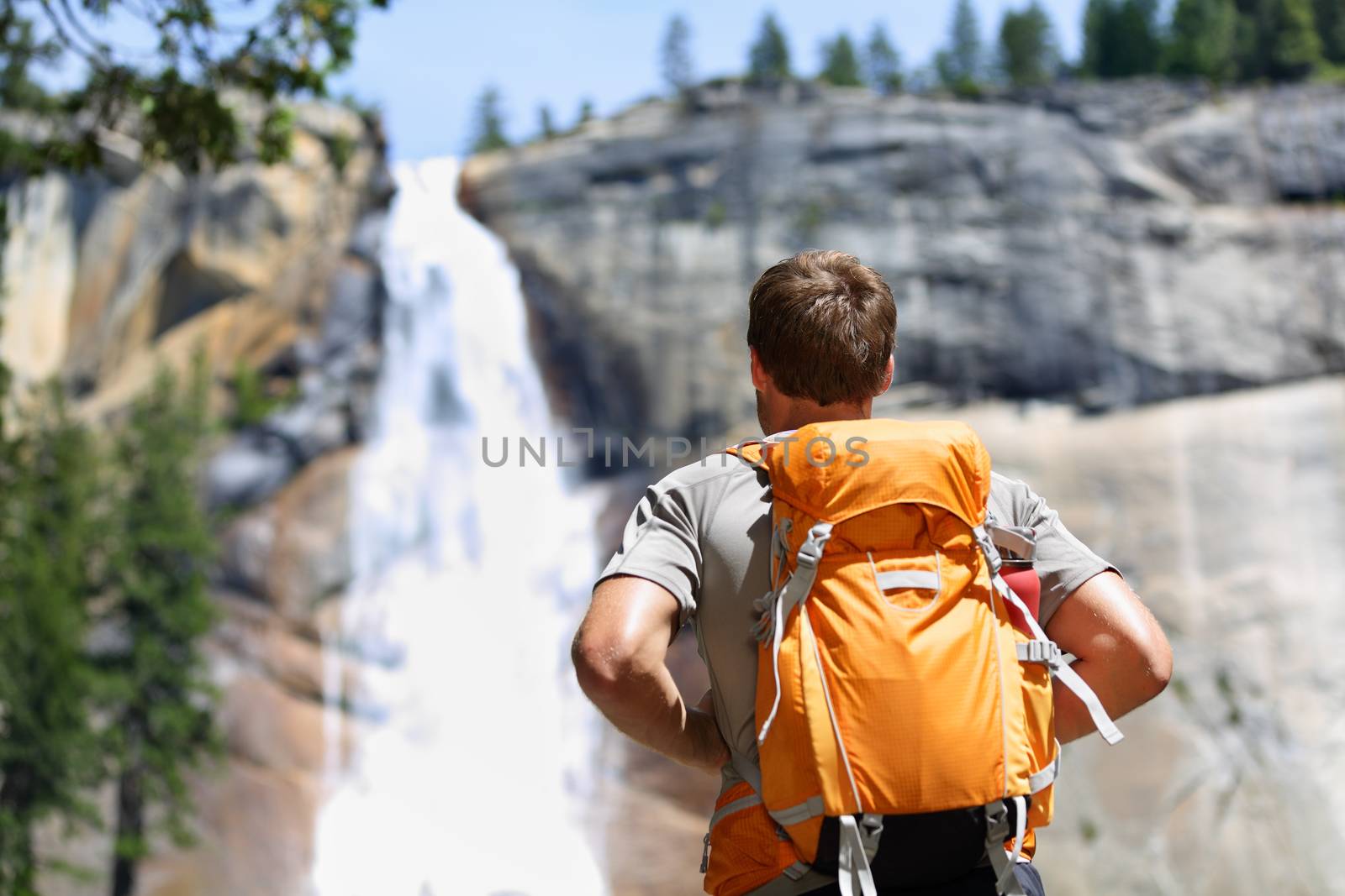 Hiker hiking looking at waterfall in Yosemite park by Maridav