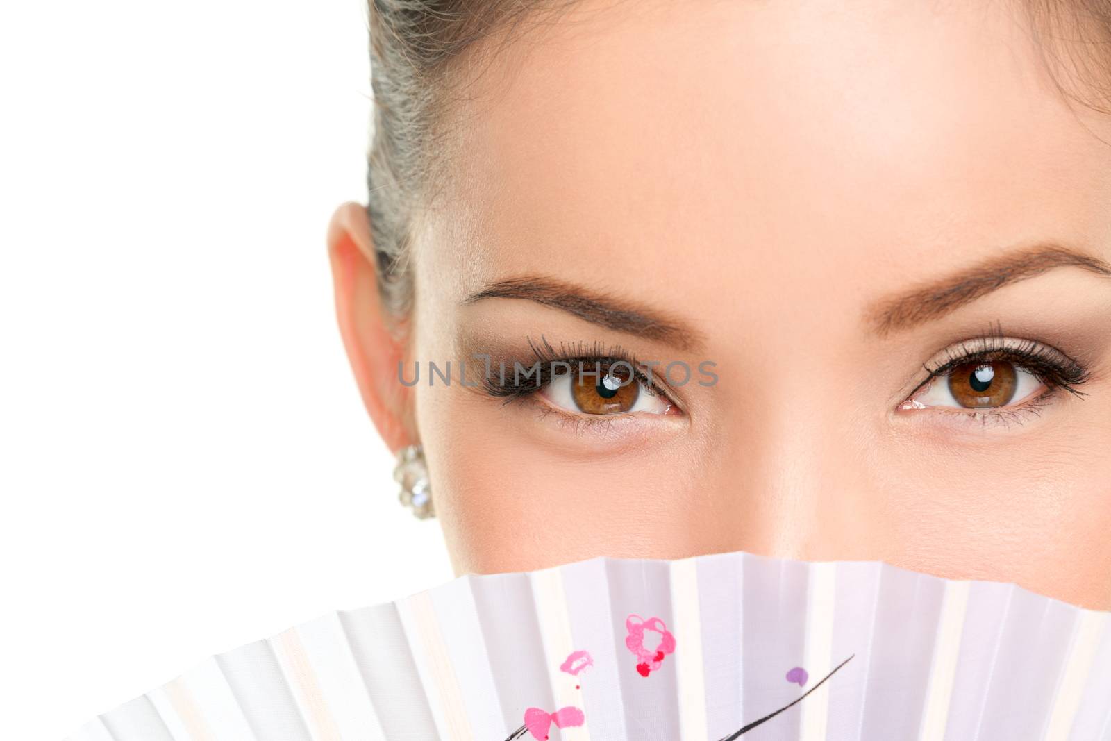 Asian beauty eyes - makeup woman looking with oriental fan. Mysterious chinese lady showing eyeliner and mascara hiding face behind accessory.