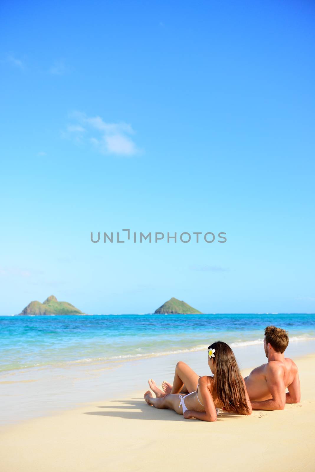 Beach vacations suntan couple relaxing in Hawaii by Maridav