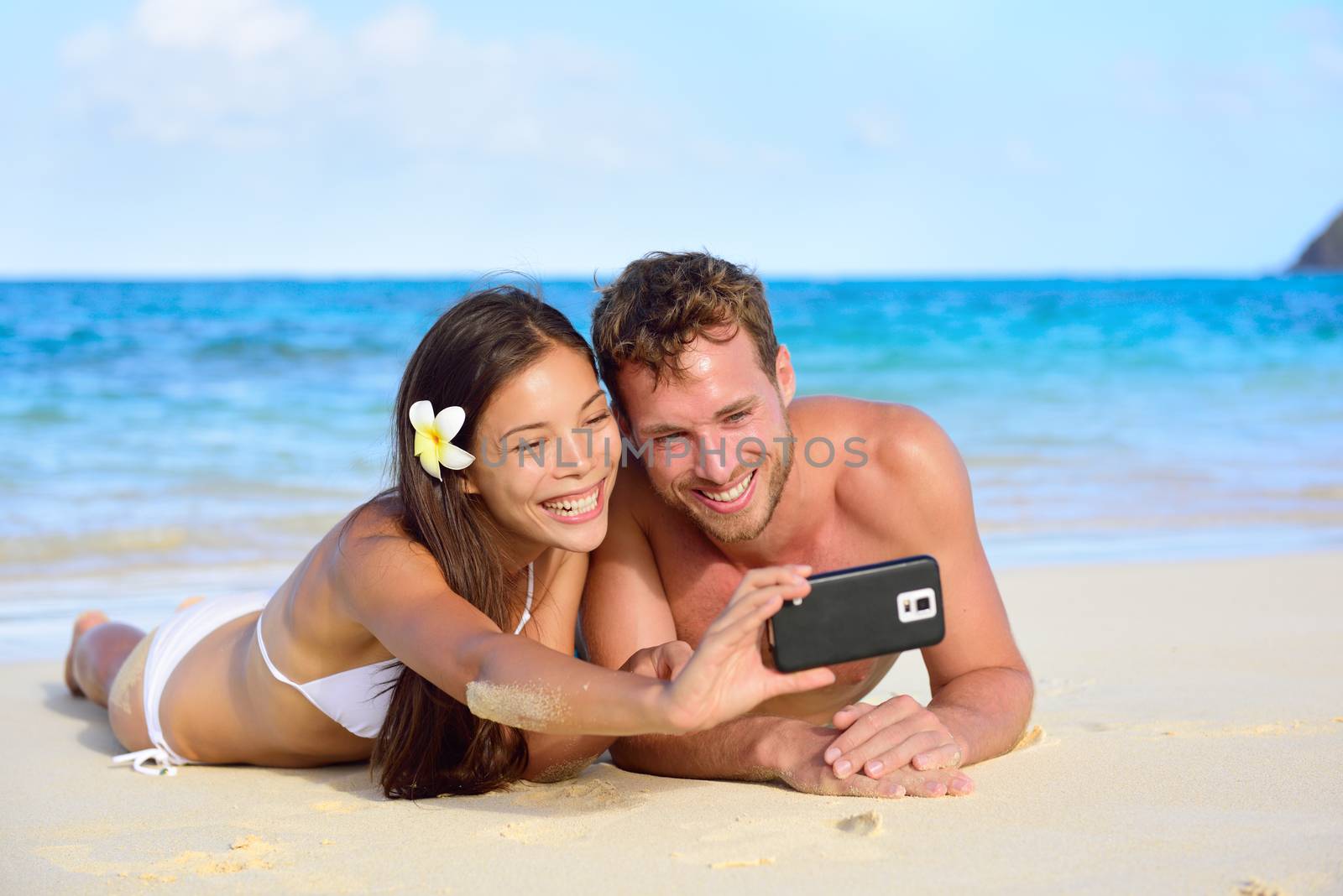 Beach holiday couple taking selfie with smartphone by Maridav