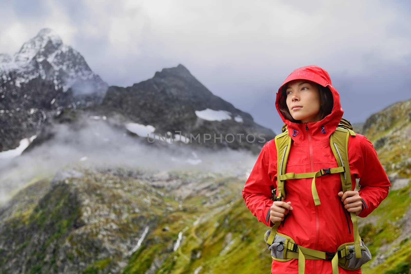 Alps Hiking - Asian hiker woman in Switzerland on trek in mountains with backpack living a healthy active lifestyle. Hiker girl on nature landscape hike in Urner Alps, Berne, Swiss alps, Switzerland.