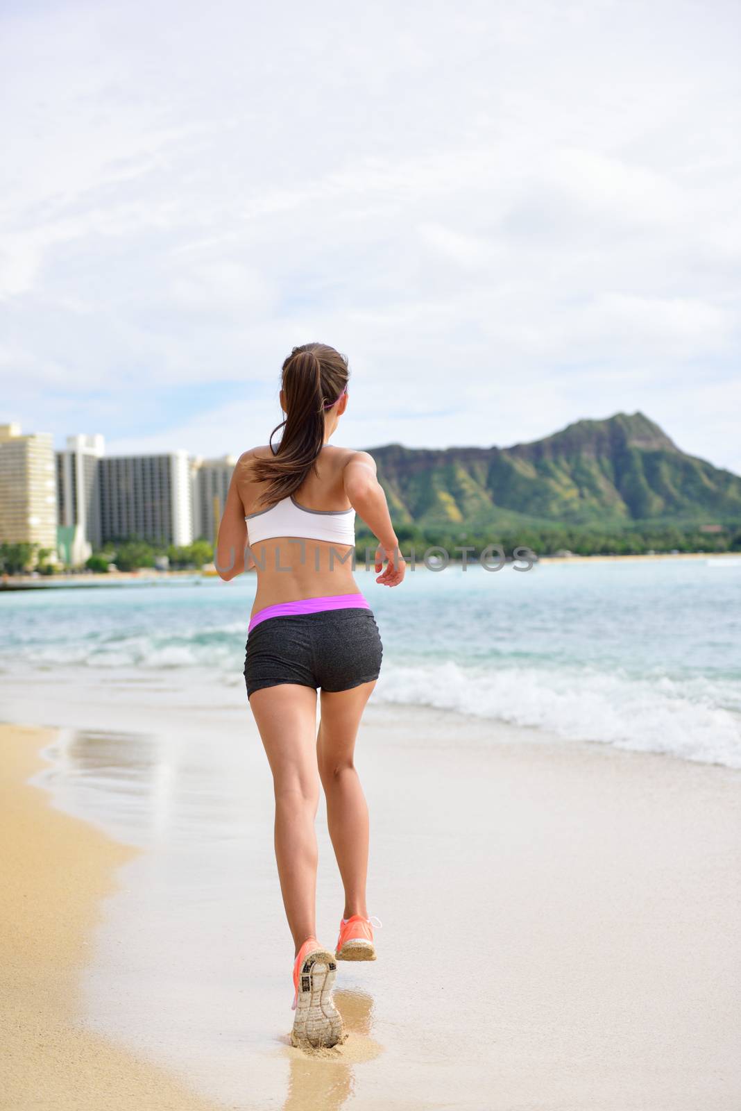 Running exercise - Female runner woman running and jogging on beach run. Athlete fitness runner jogger training living healthy active lifestyle exercising on Waikiki Beach, Honolulu, Oahu, Hawaii, USA