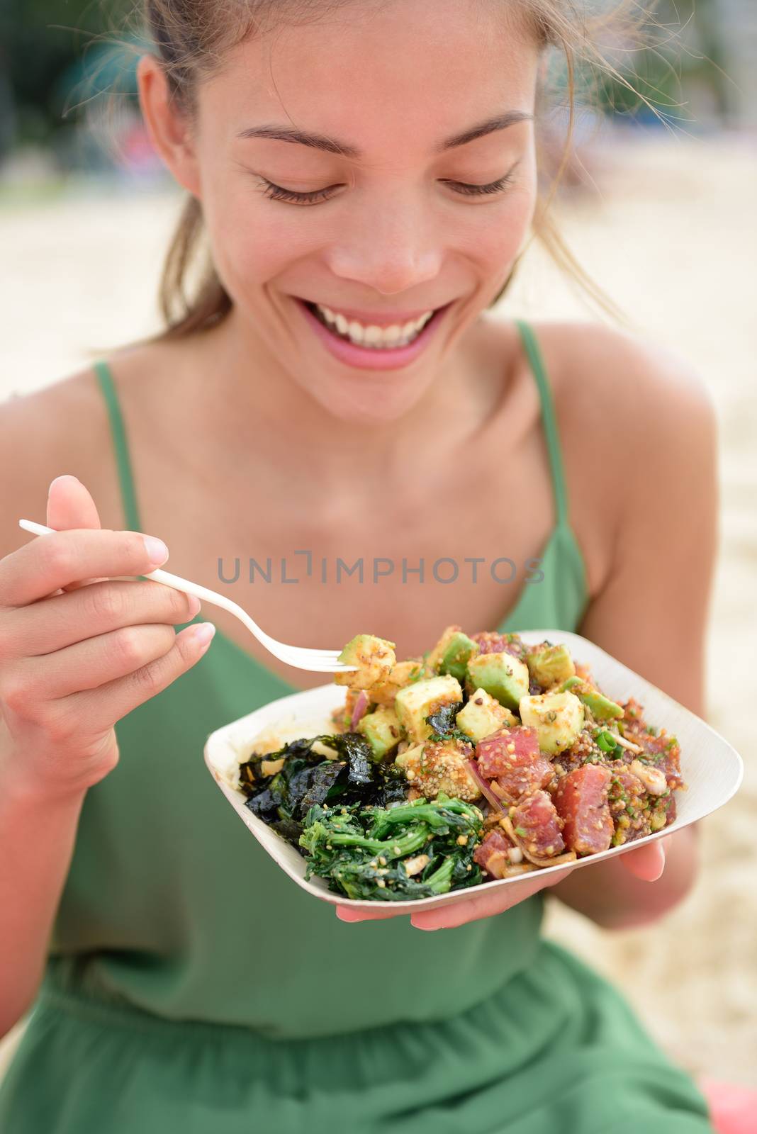 Woman eating local Hawaii food Poke bowl salad by Maridav