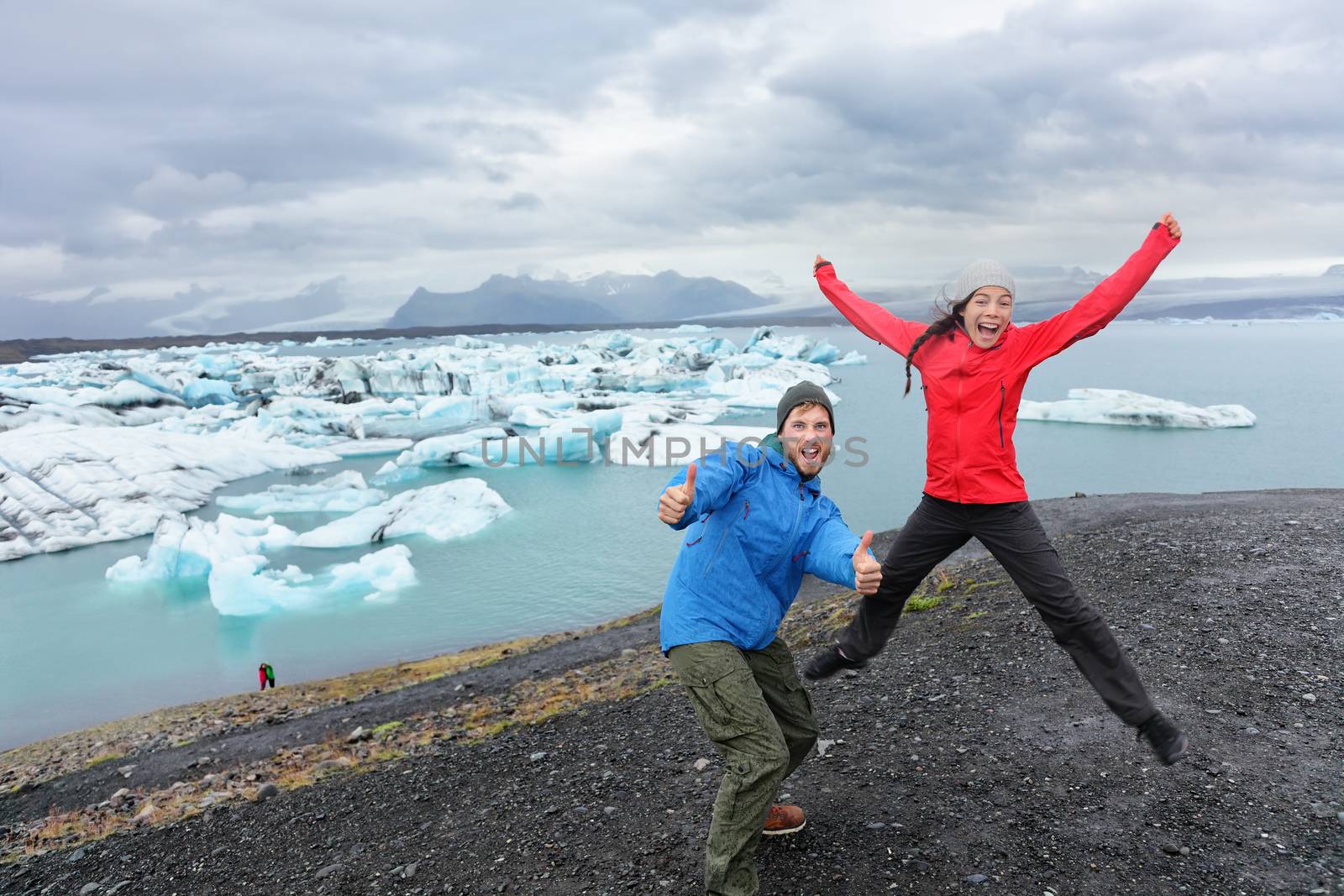 Travel people couple having fun jumping on Iceland by Maridav