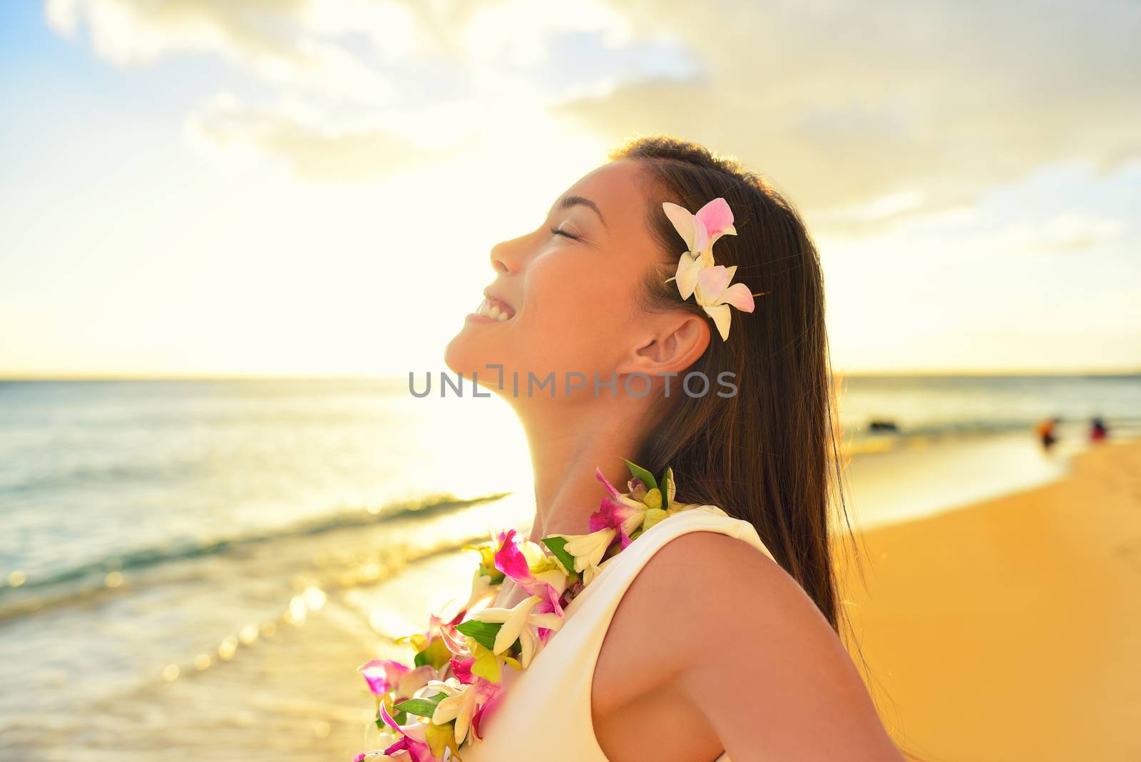 Happy carefree woman free relaxing in Hawaii on hawaiian beach vacation. Beautiful woman in the golden sunshine glow of sunset breathing fresh air enjoying peace, serenity in nature.