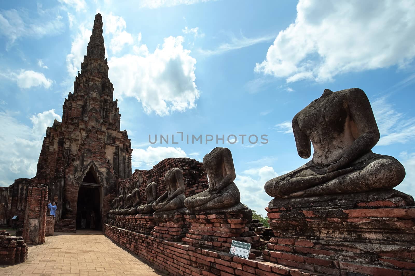 Ayutthaya, Thailand - August 22, 2018: Old pagoda and ruined Buddha statue in Chaiwatthanaram temple. This is the famous travel destination in Ayutthaya province, Thailand.