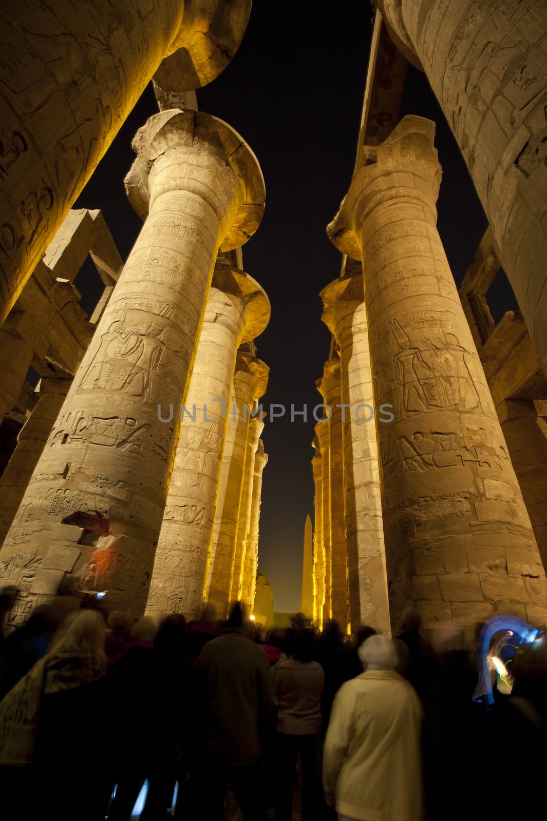 Columns in the ancient egyptian temple of Karnak at Luxor with hieroglyphic carvings lit up during the night sound and light show