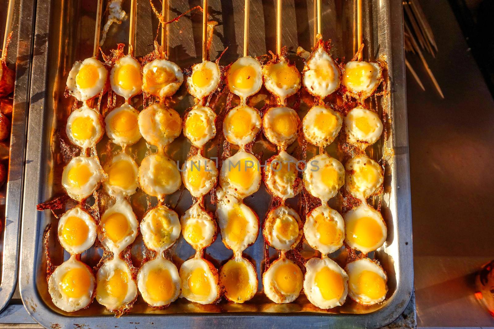 Small grilled omelettes on the sticks. Chinese traditional street food from Wangfujing Street in Beijing.