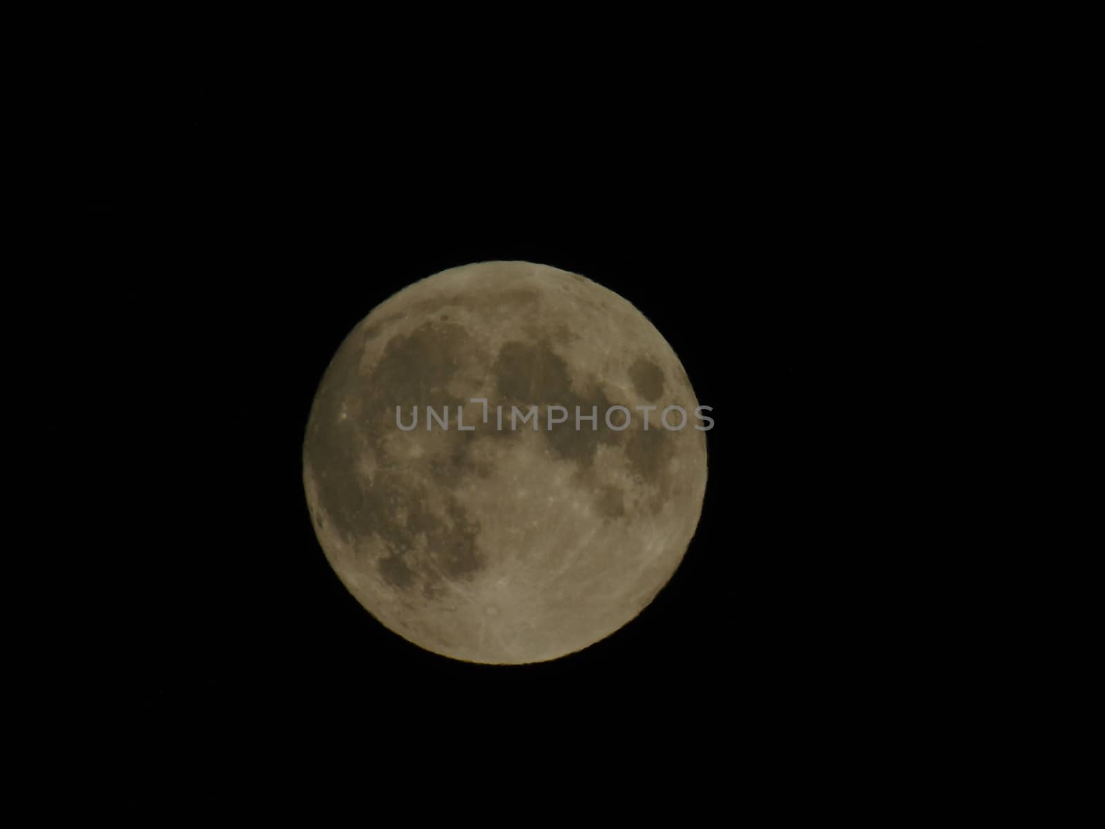 Genova, Italy - 07/05/2020: An amazing photography of the full moon over the city of Genova by night with a great clear and blue sky in the background and some stars.