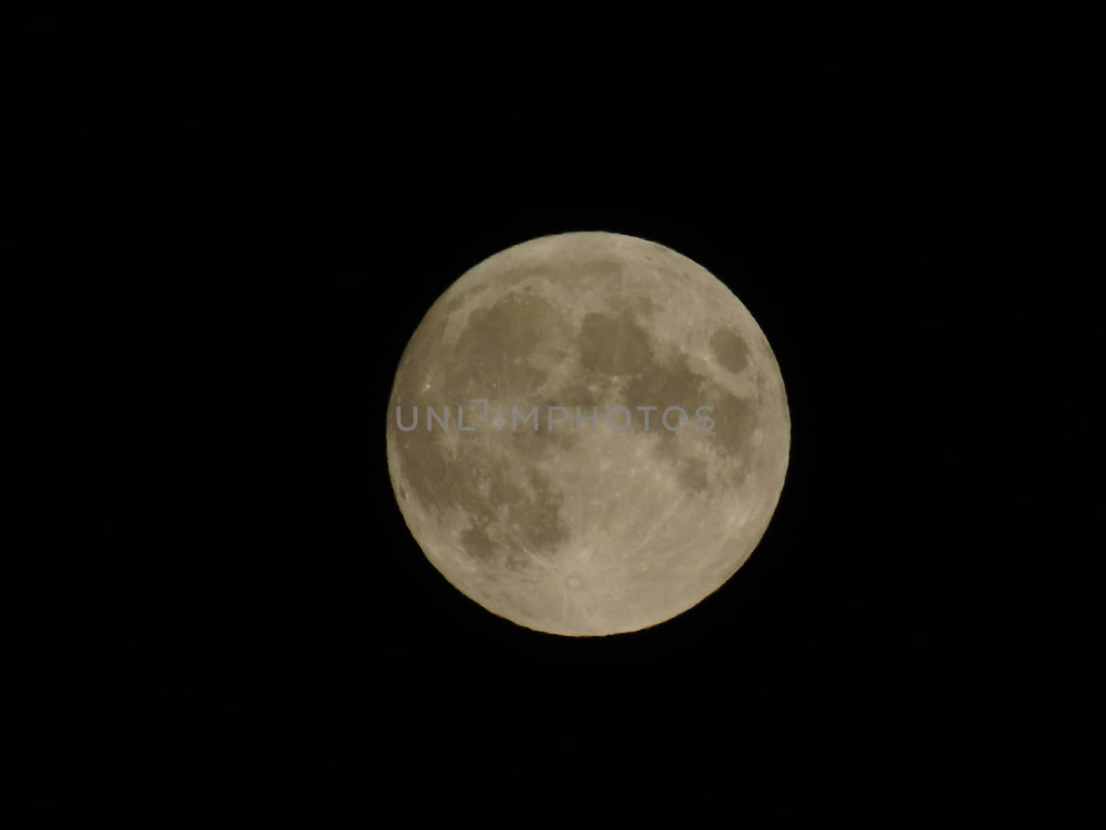 Genova, Italy - 07/05/2020: An amazing photography of the full moon over the city of Genova by night with a great clear and blue sky in the background and some stars.