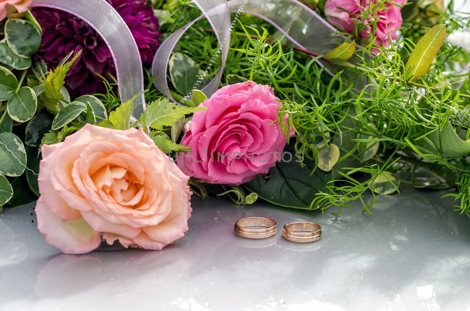 Flower decoration and a ring set on gray wedding car bonnet.