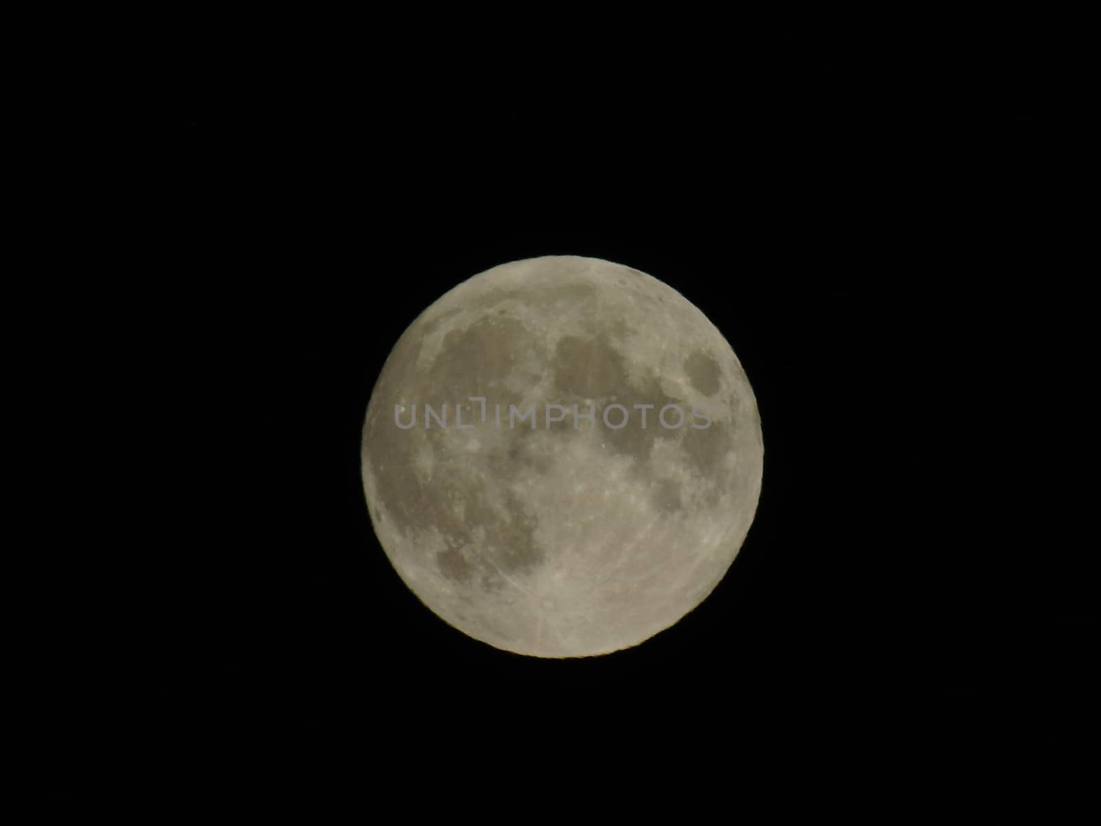 Genova, Italy - 07/05/2020: An amazing photography of the full moon over the city of Genova by night with a great clear and blue sky in the background and some stars.