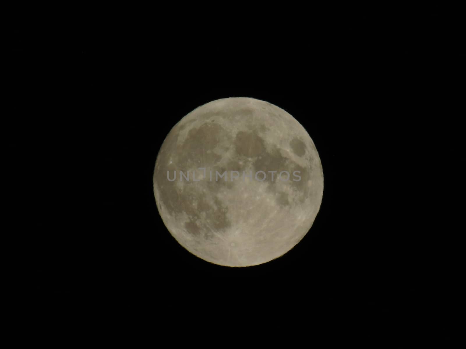 Genova, Italy - 07/05/2020: An amazing photography of the full moon over the city of Genova by night with a great clear and blue sky in the background and some stars.