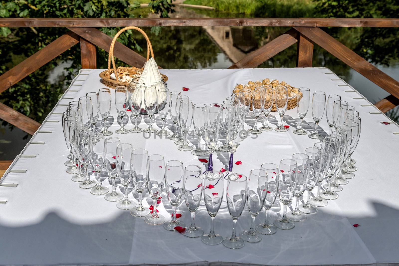 Wedding table decoration. Heart-shaped arranged champagne glasses by askoldsb