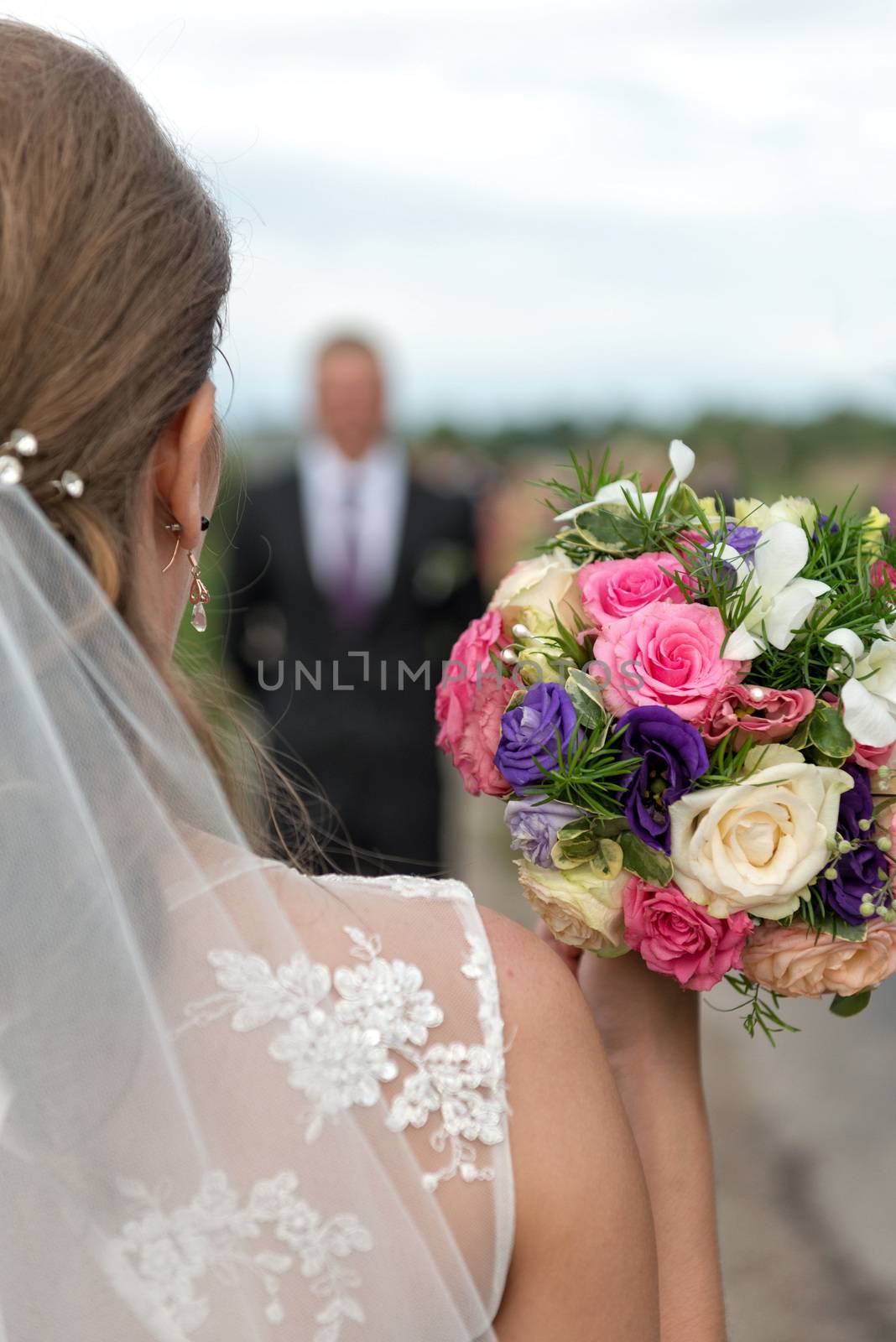 Bride with bridal bouquet in the hands of the groom expect. by askoldsb