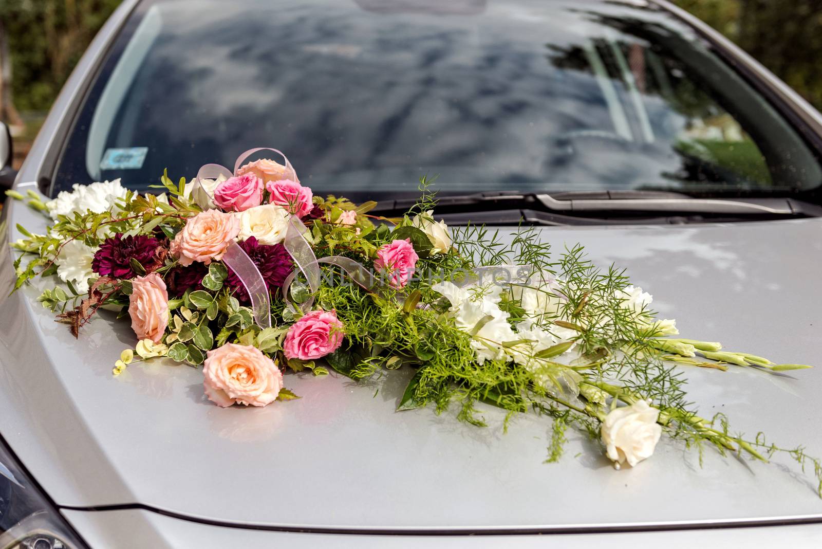 Flower decoration on gray wedding car bonnet.
