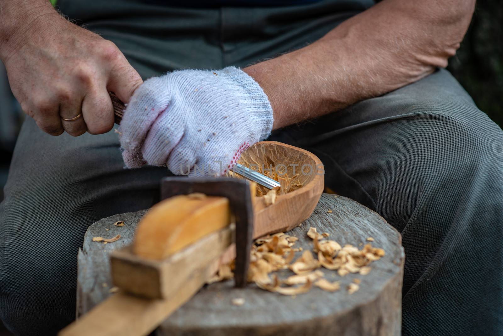Craftsman demonstrates the process of making wooden spoons handmade using tools. National crafts concept.