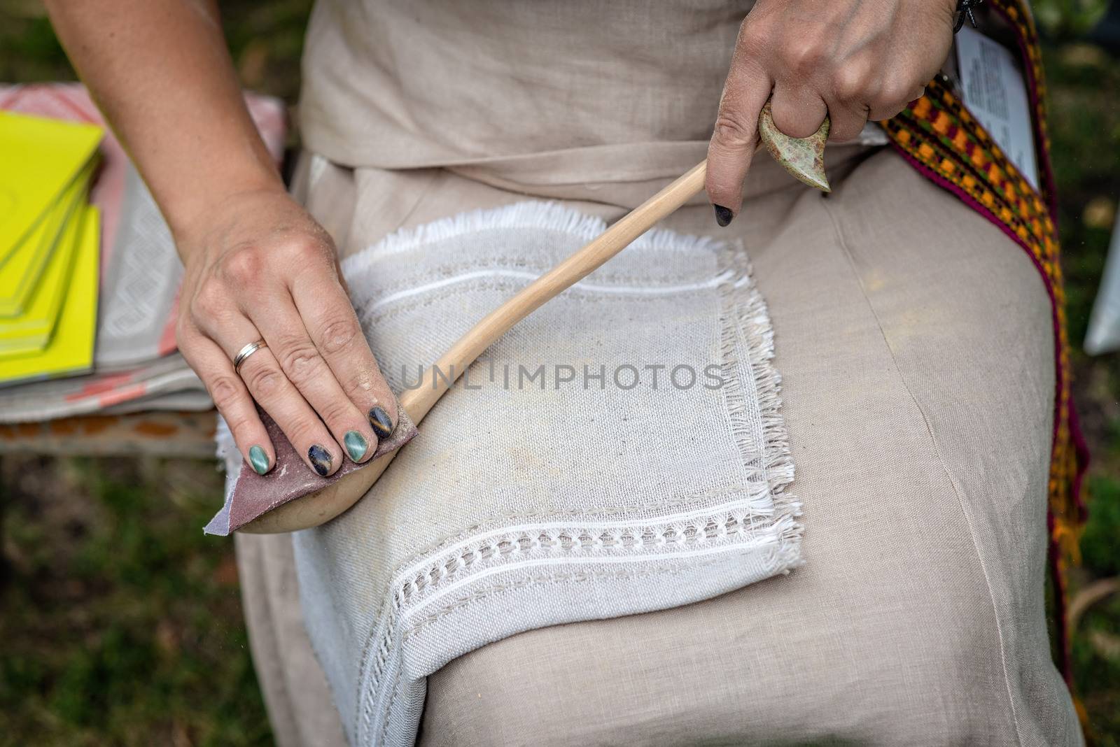 the woman makes traditional handcraft wooden spoon. - Image