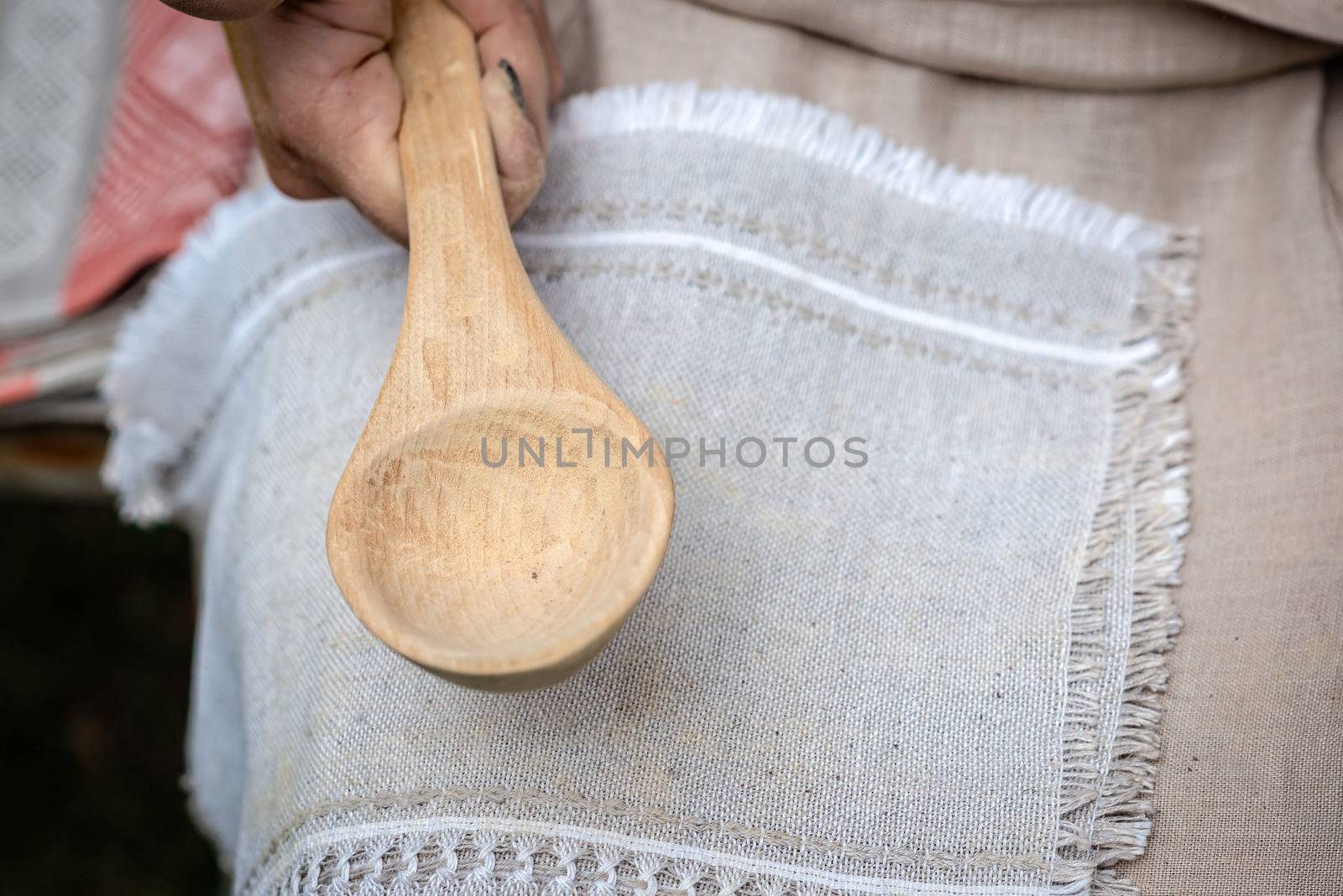 the woman makes traditional handcraft wooden spoon. - Image