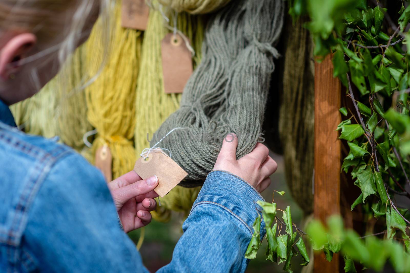 Traditional latvian craft market. Woman looking for yarn. - image