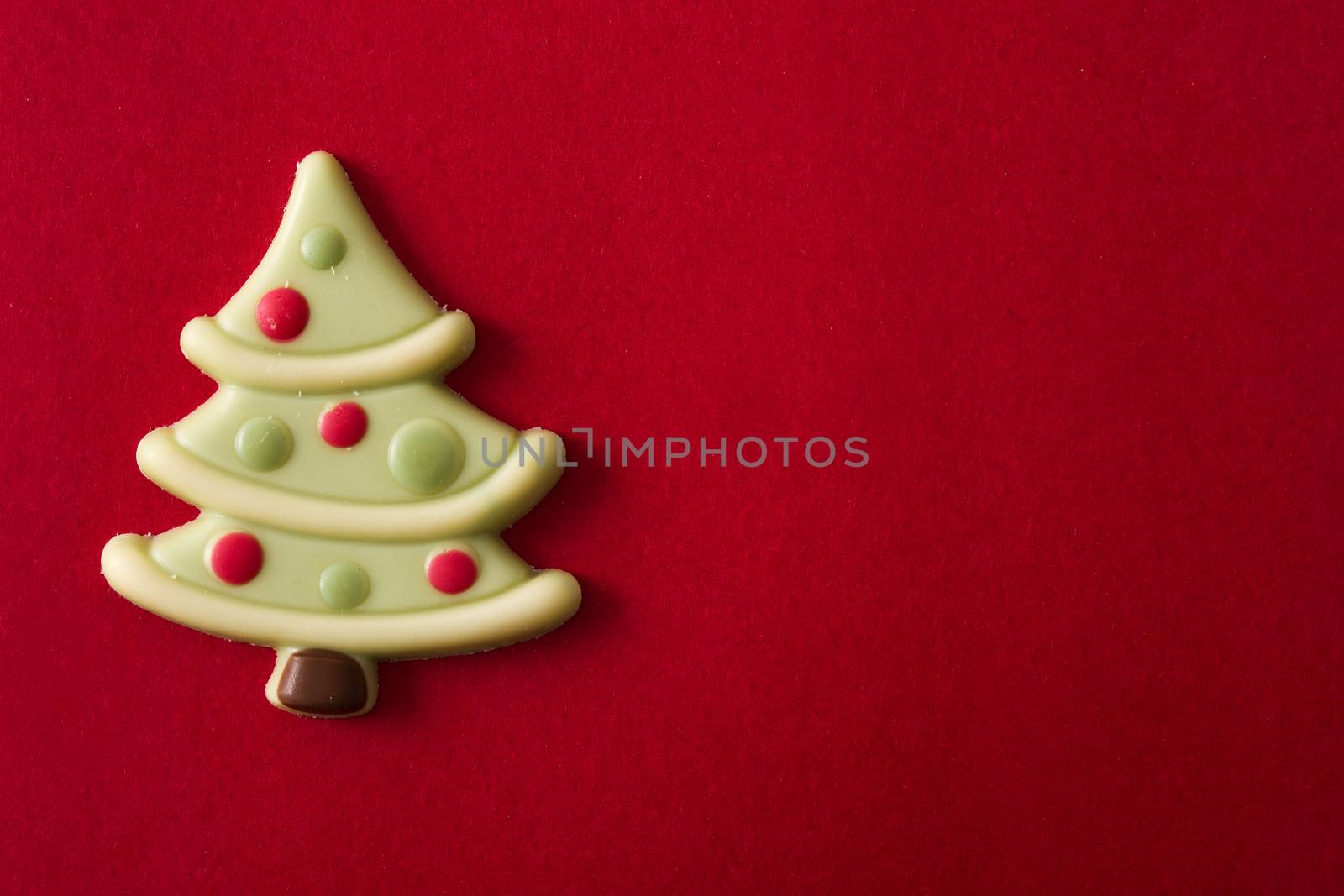 Christmas tree chocolate bonbon on red background