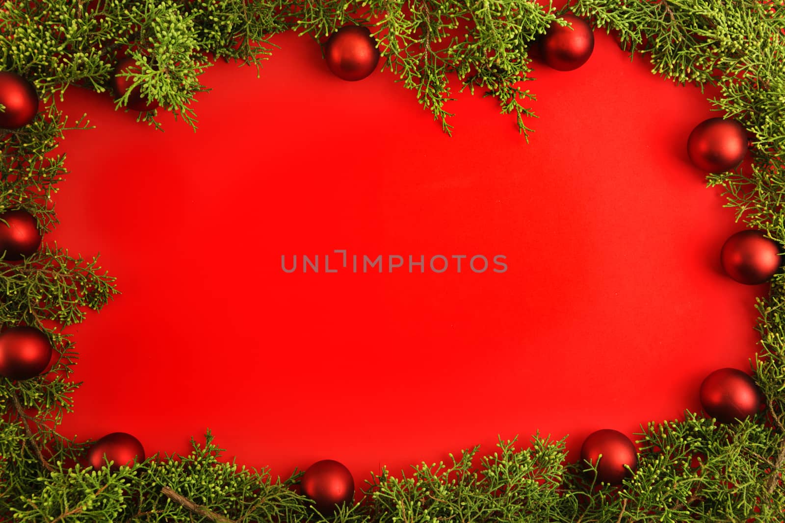 Flat lay red Christmas copy space with pine branches and red Christmas baubles all around by robbyfontanesi