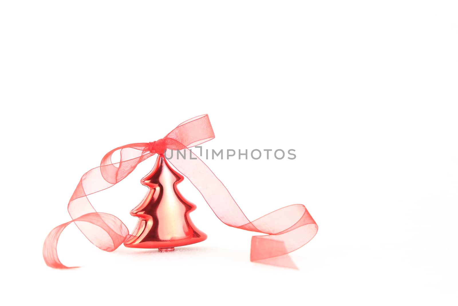 Isolated red Christmas tree bauble with red organza ribbon on white background