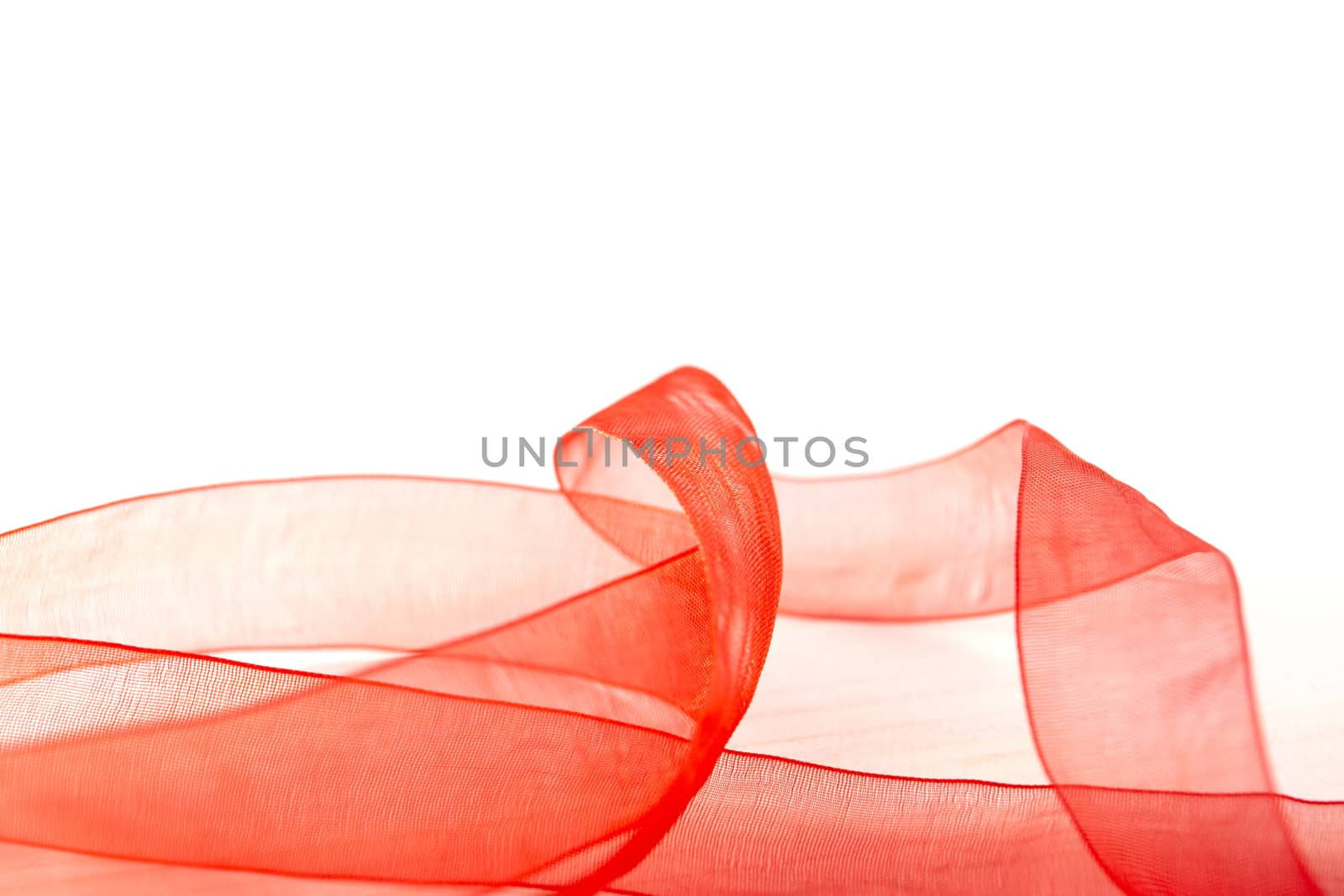 Elegant plays of color and transparency with a red organza ribbon that winds over a white background copy space by robbyfontanesi