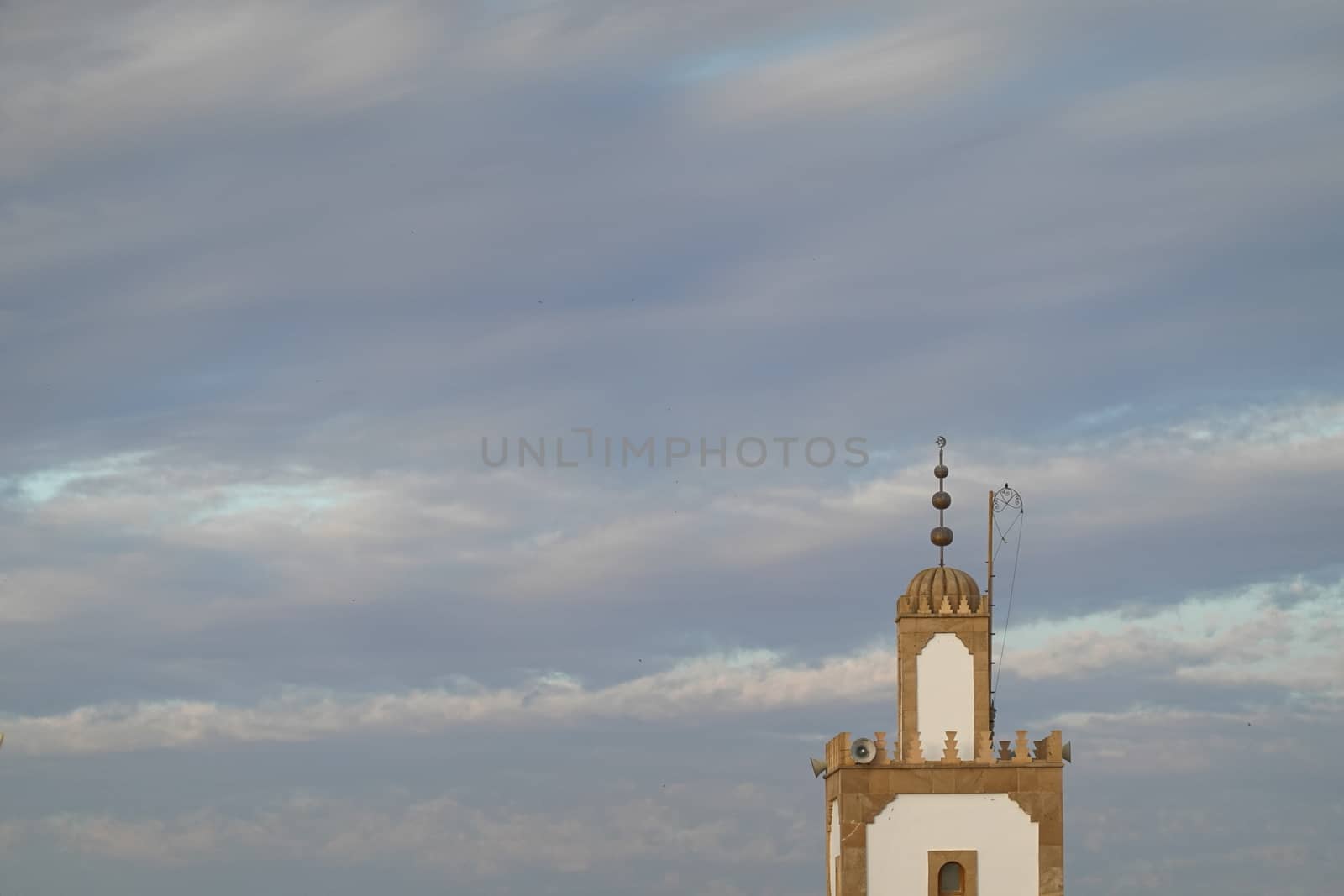 a mosk tower in a blue sky full of beautiful clouds.