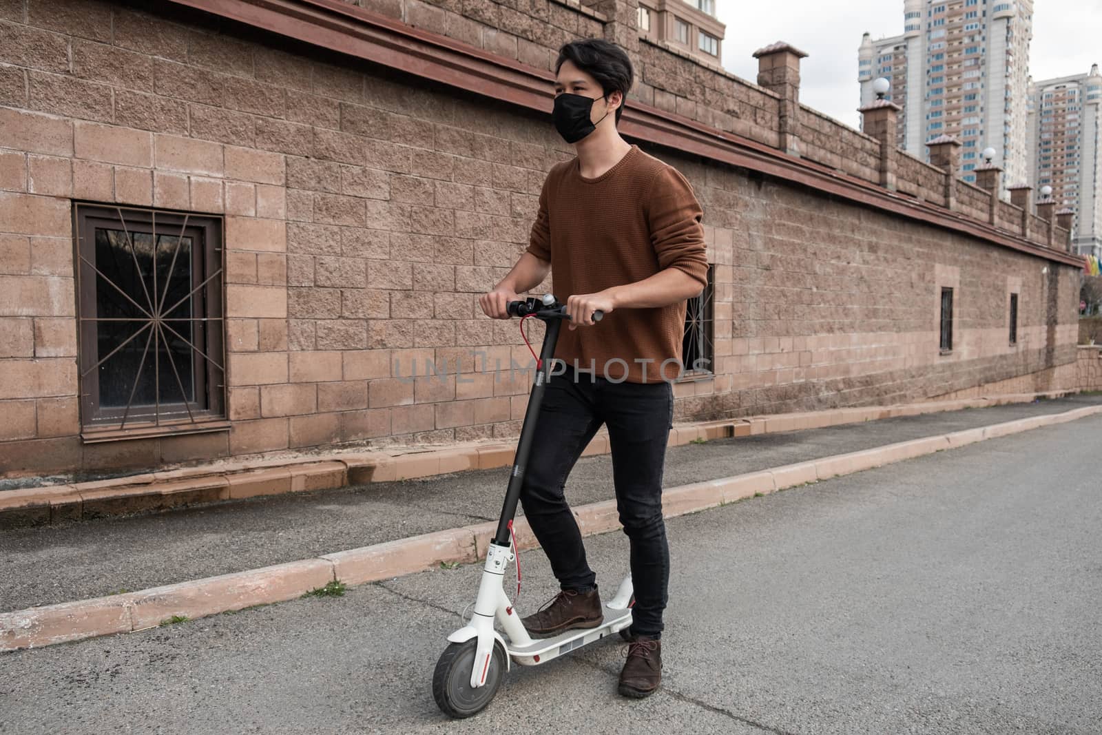 Young man riding a scooter in the city