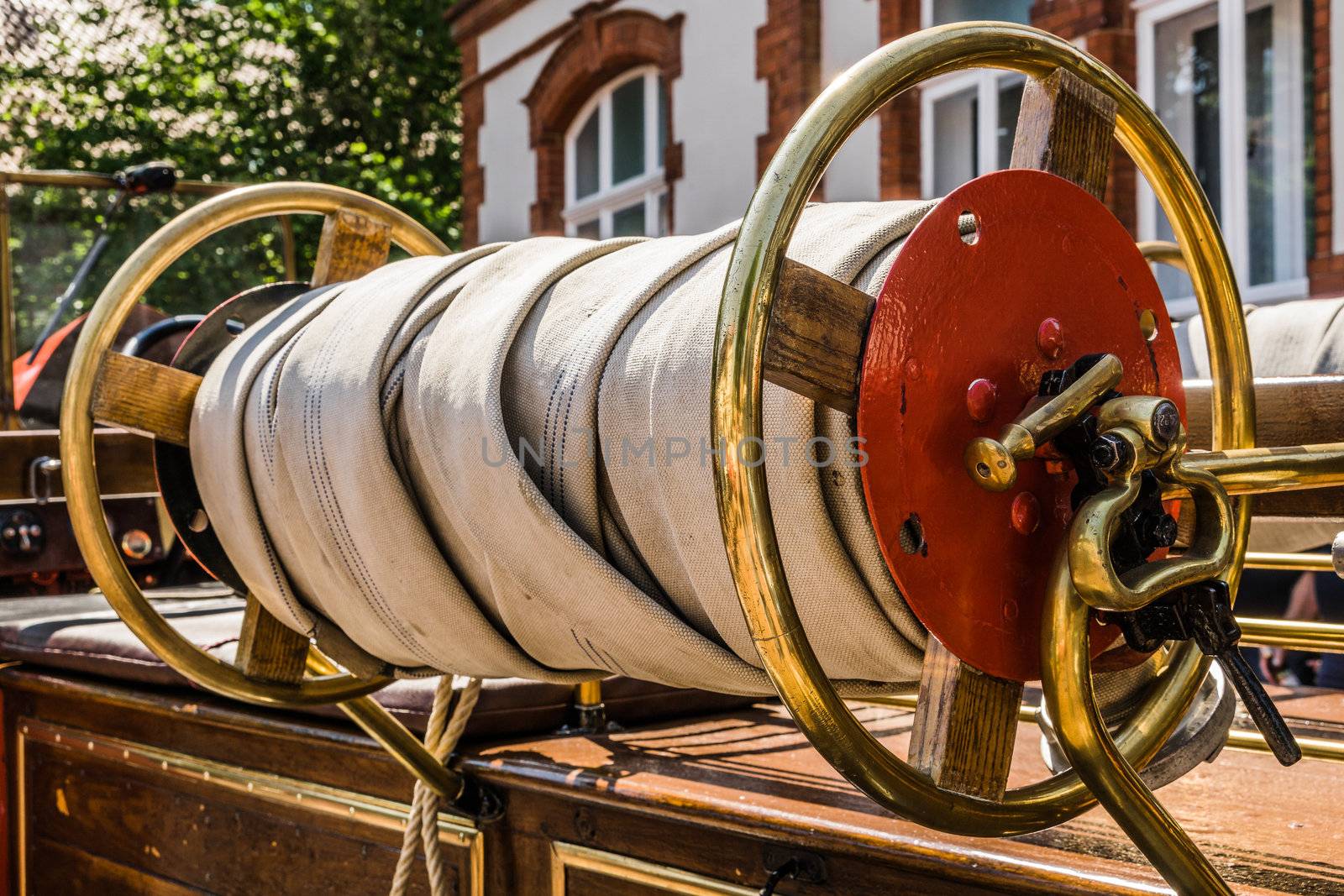 Rolled up hose of a historical fire engine of the fire brigade at an oldtimer exhibition by geogif