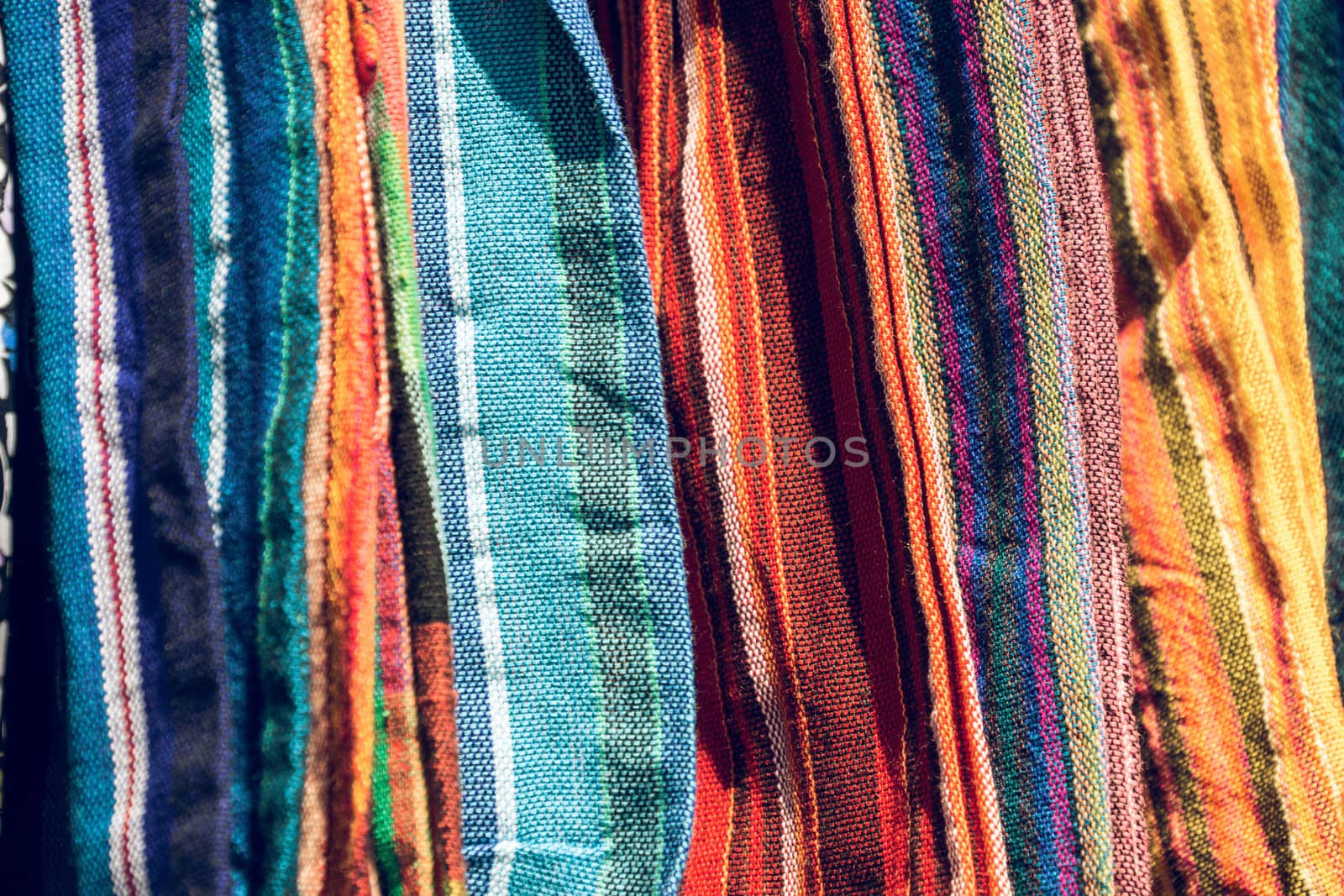 Abstract detail of a pile of colourful fabrics at a flea market by geogif