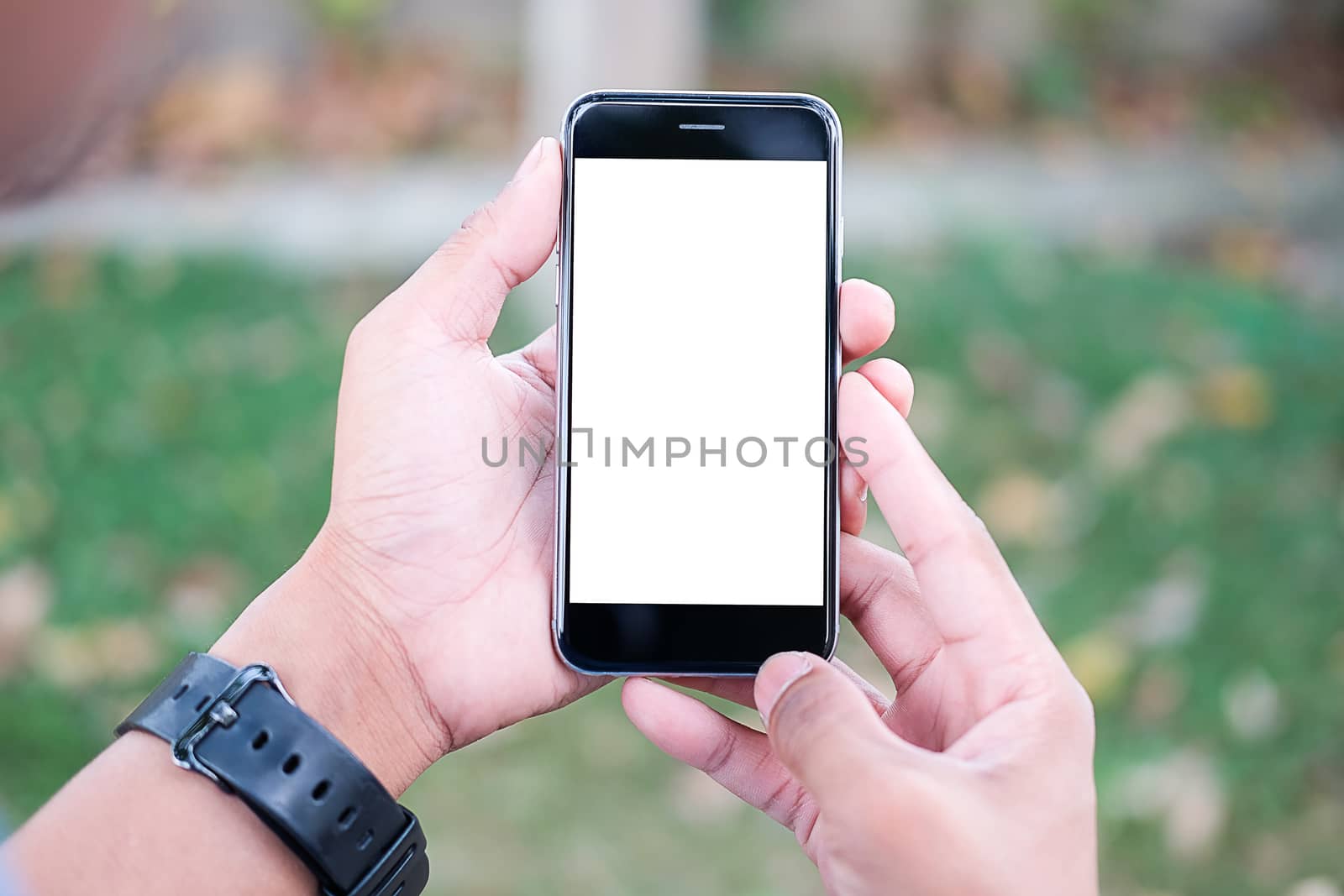 Cropped shot view of man hands holding smart phone with blank copy space screen for your text message or information content, female reading text message on cell telephone during in urban setting. 