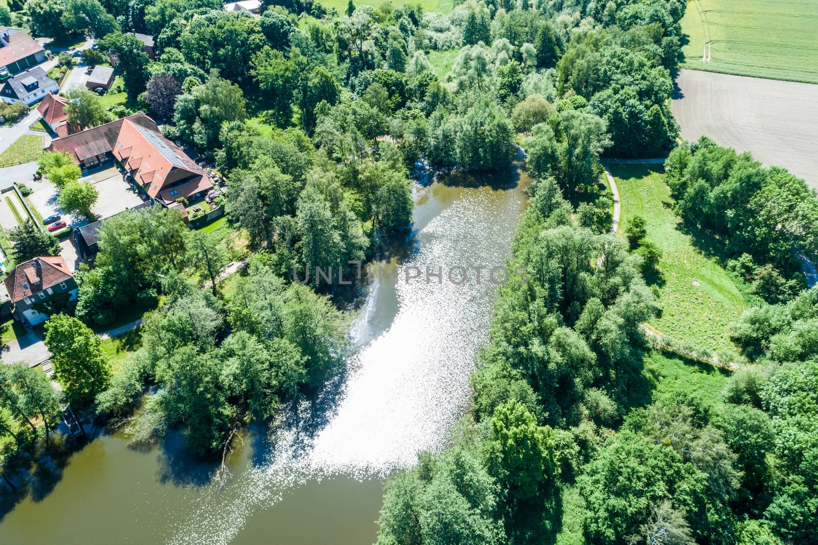 The pond at the moated castle Neuhaus from the air, with bushes and trees, at the edge of the village by geogif