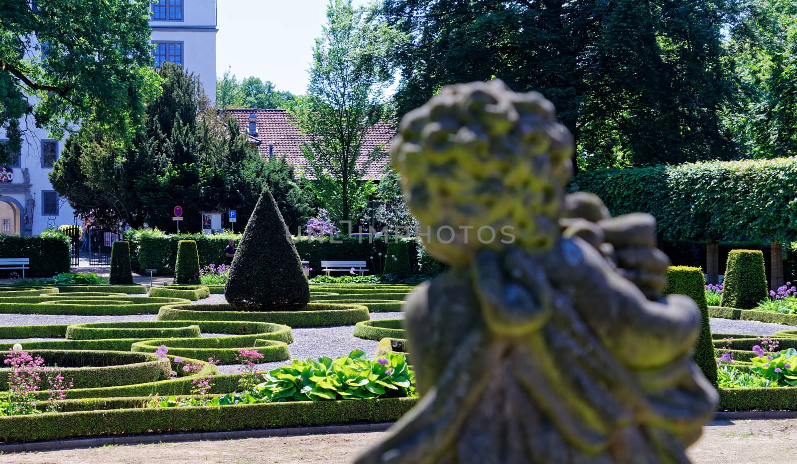 Baroque garden with a deliberately blurred stone figure in the foreground, germany