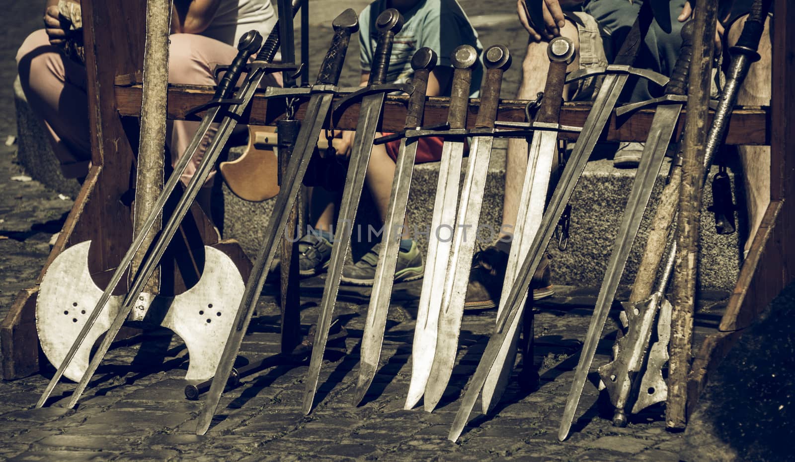 Swords set up in a row for the knight demonstration at a medieval market by geogif