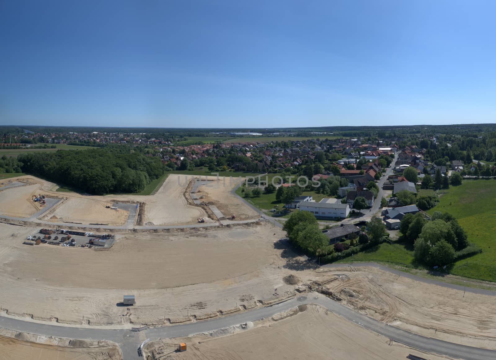 Aerial panorama in high resolution of a construction site at the edge of a village, Germany