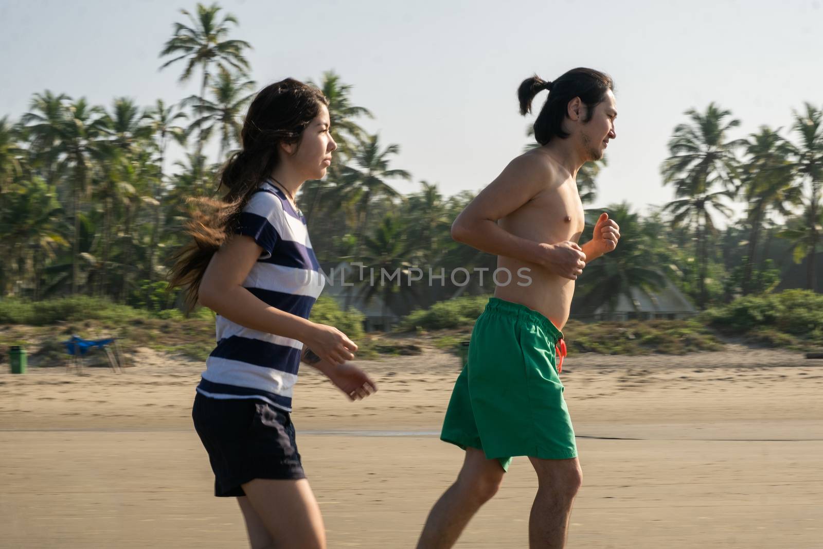 Couple running at the Vagator Beach, Goa, India