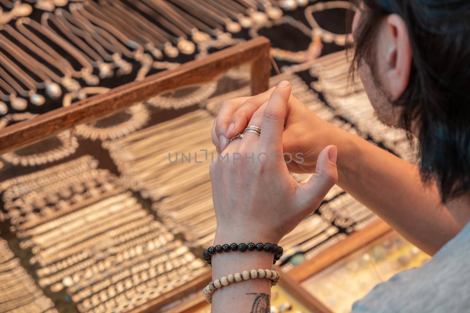 Guy tries on silver rings in india market by snep_photo