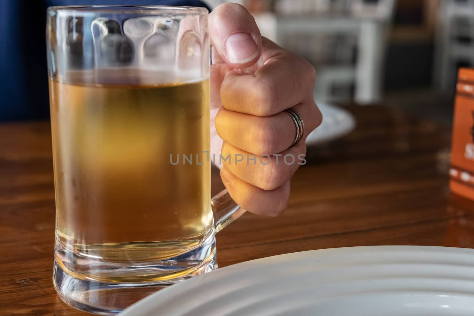 Man's hand holding beer glass