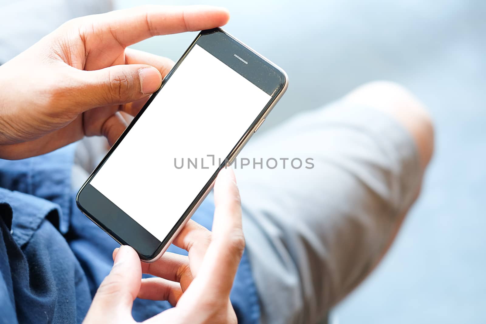 Cropped shot view of man hands holding smart phone with blank copy space screen for your text message or information content, female reading text message on cell telephone during in urban setting. 