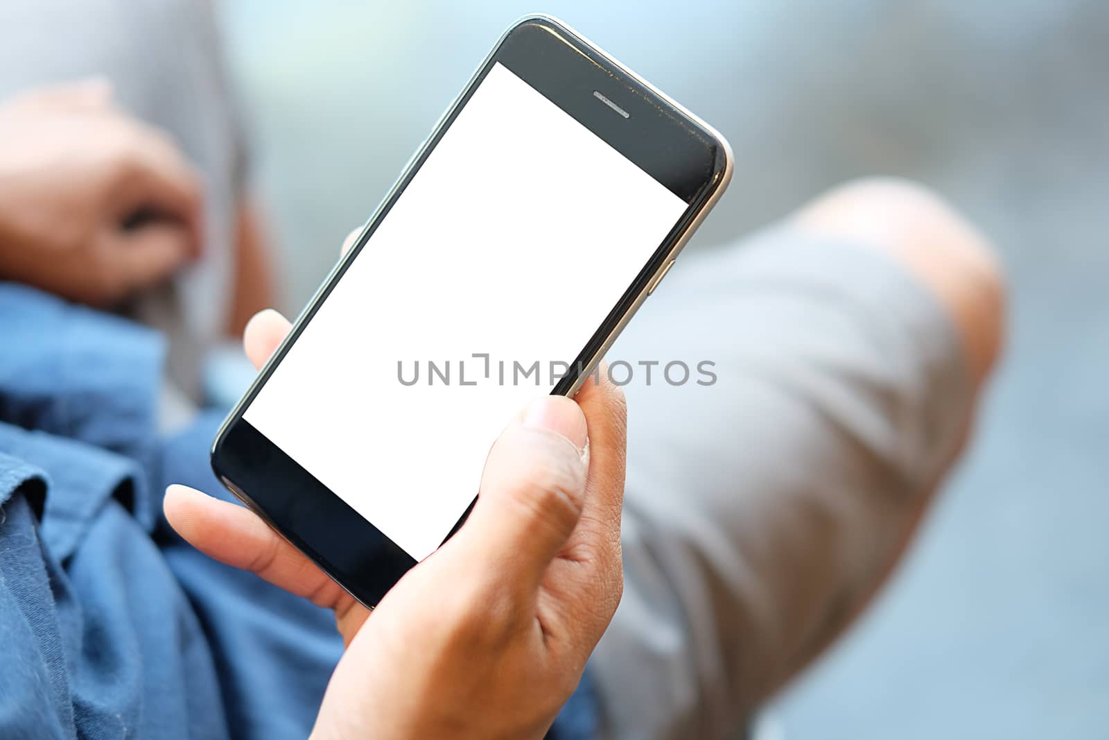 Cropped shot view of man hands holding smart phone with blank copy space screen for your text message or information content, female reading text message on cell telephone during in urban setting. 